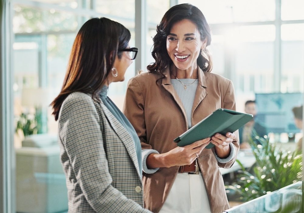 Tablet, conversation and business people in office with research for break in finance stock market. Meeting, technology and female financial advisors with online revenue, profit or equity report